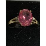 A 9 CARAT GOLD RING WITH A LARGE PINK CENTRE STONE SIZE Q GROSS WEIGHT 1.7 GRAMS