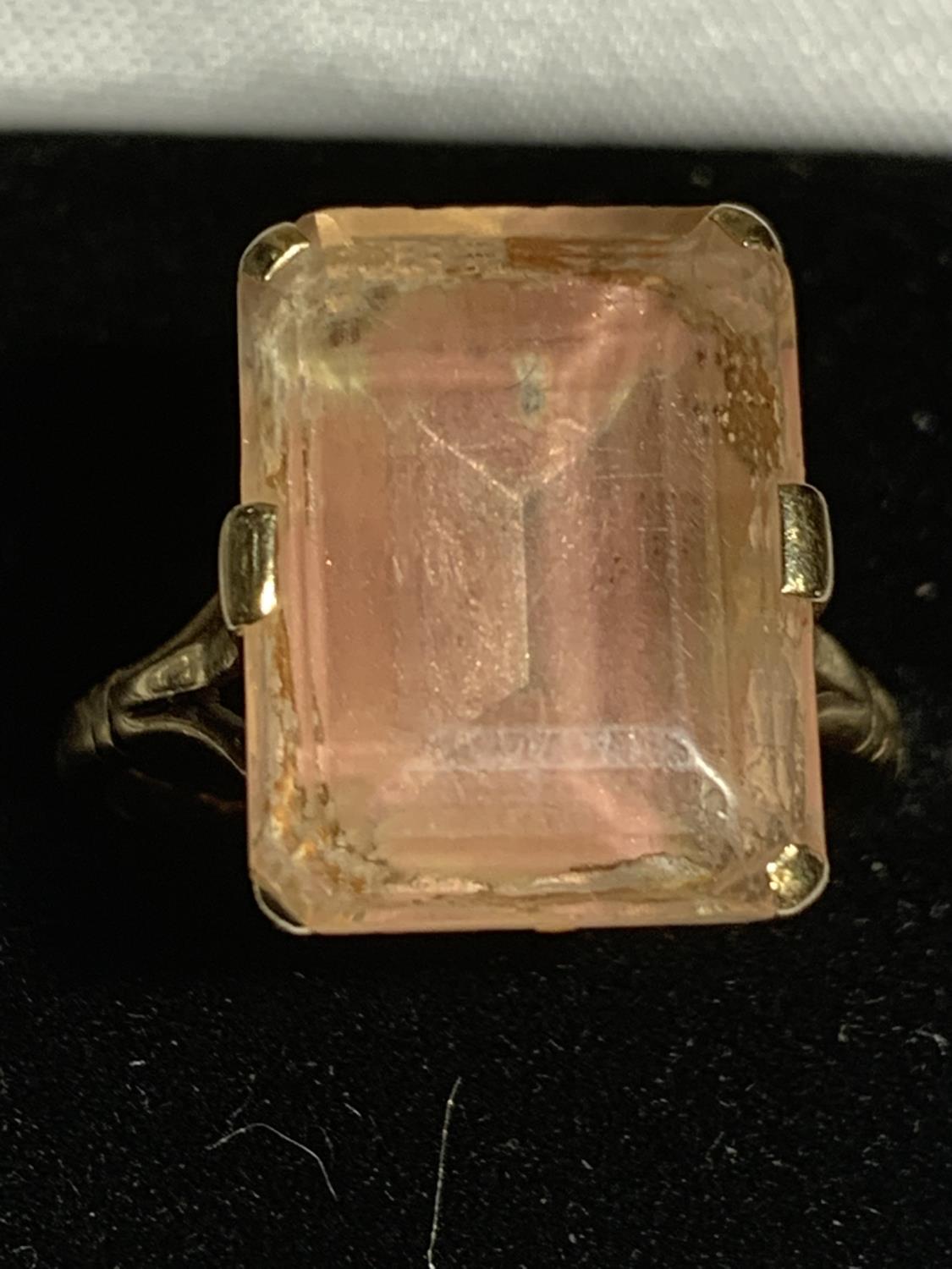 A 9 CARAT GOLD RING WITH A LARGE CORAL TINGED CENTRE STONE SIZE N/O GROSS WEIGHT 4.8 GRAMS