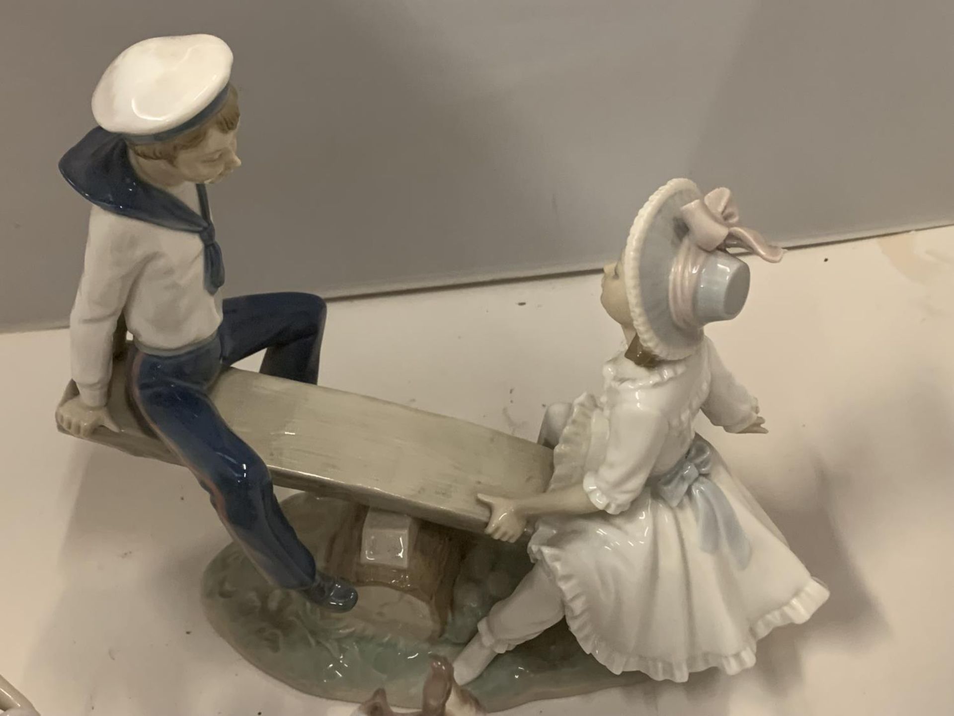 TWO LLADRO FIGURINES, ONE OF A BOY AND GIRL ON A SEE-SAW, THE OTHER OF A GIRL WITH A BASKET OF - Image 2 of 5
