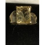 A 9 CARAT GOLD RING WITH A LARGE YELLOW COLOURED CENTRE STONE SIZE N/O GROSS WEIGHT 5.2 GRAMS