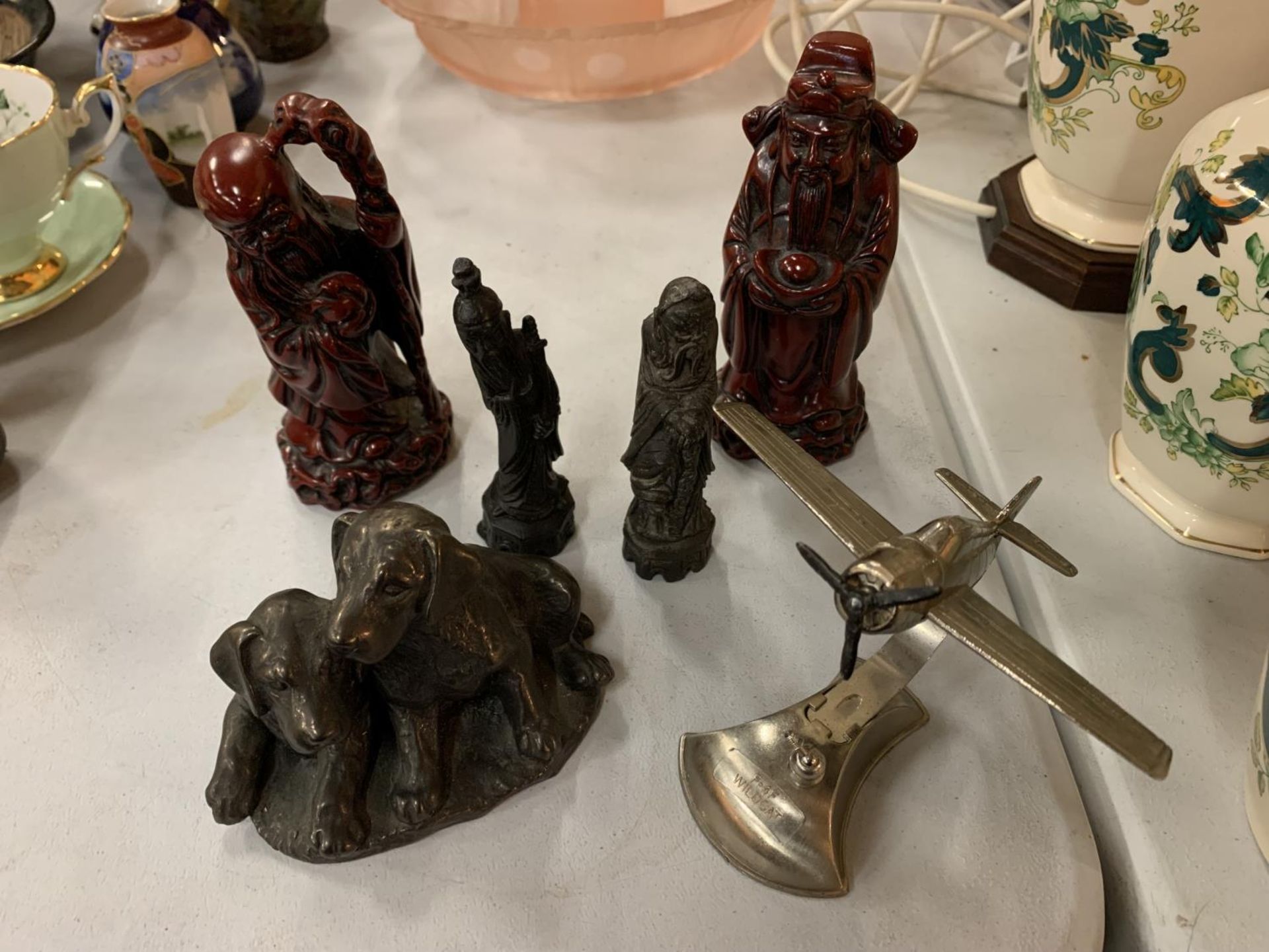AN AEROPLANE ON A STAND, FOUR ORIENTAL FIGURES AND A DOG ORNAMENT