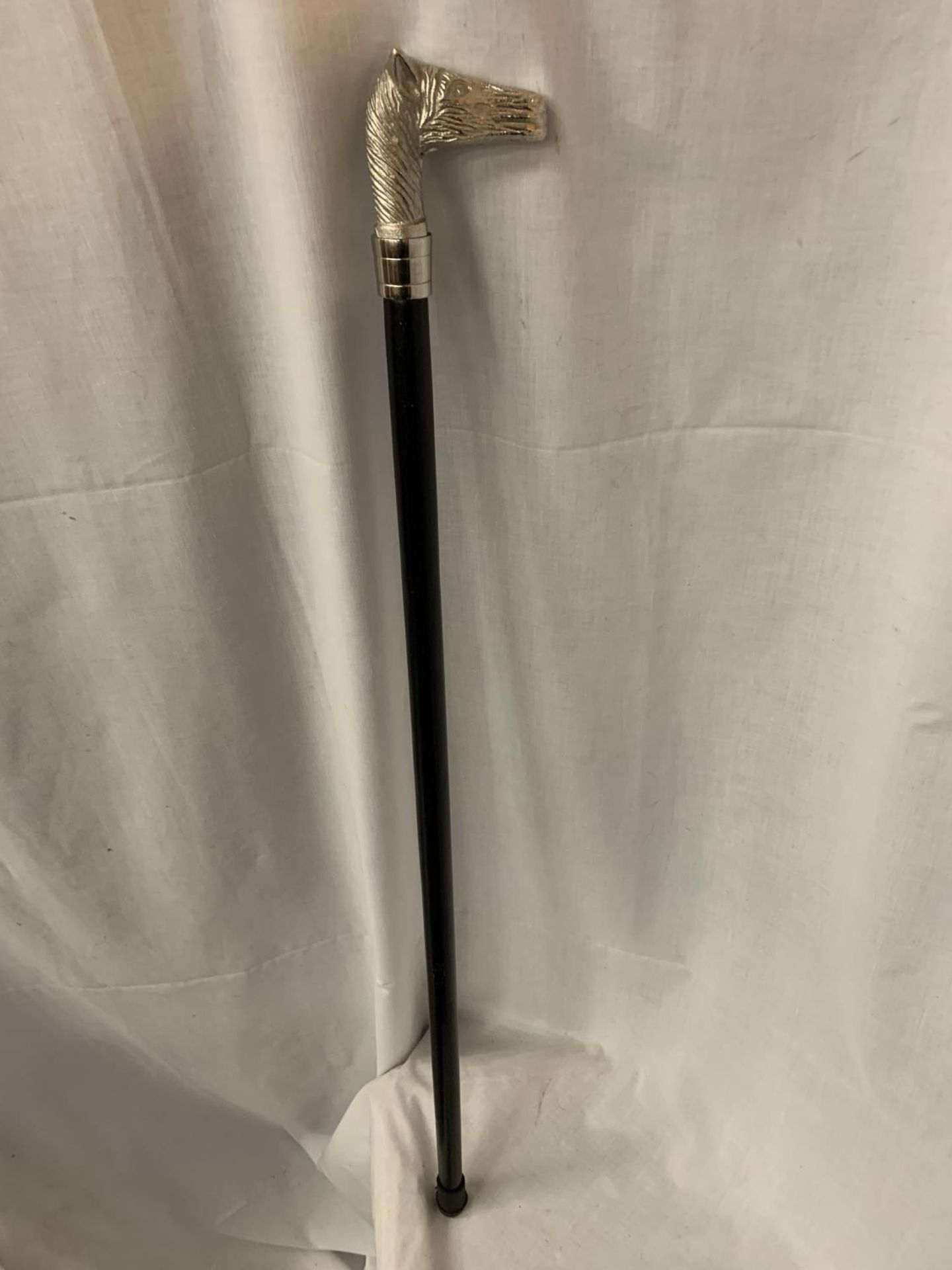 A WALKING CANE WITH A SILVER COLOURED HORSES HEAD TOP