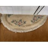 AN OVAL FLORAL PATTERNED RUG