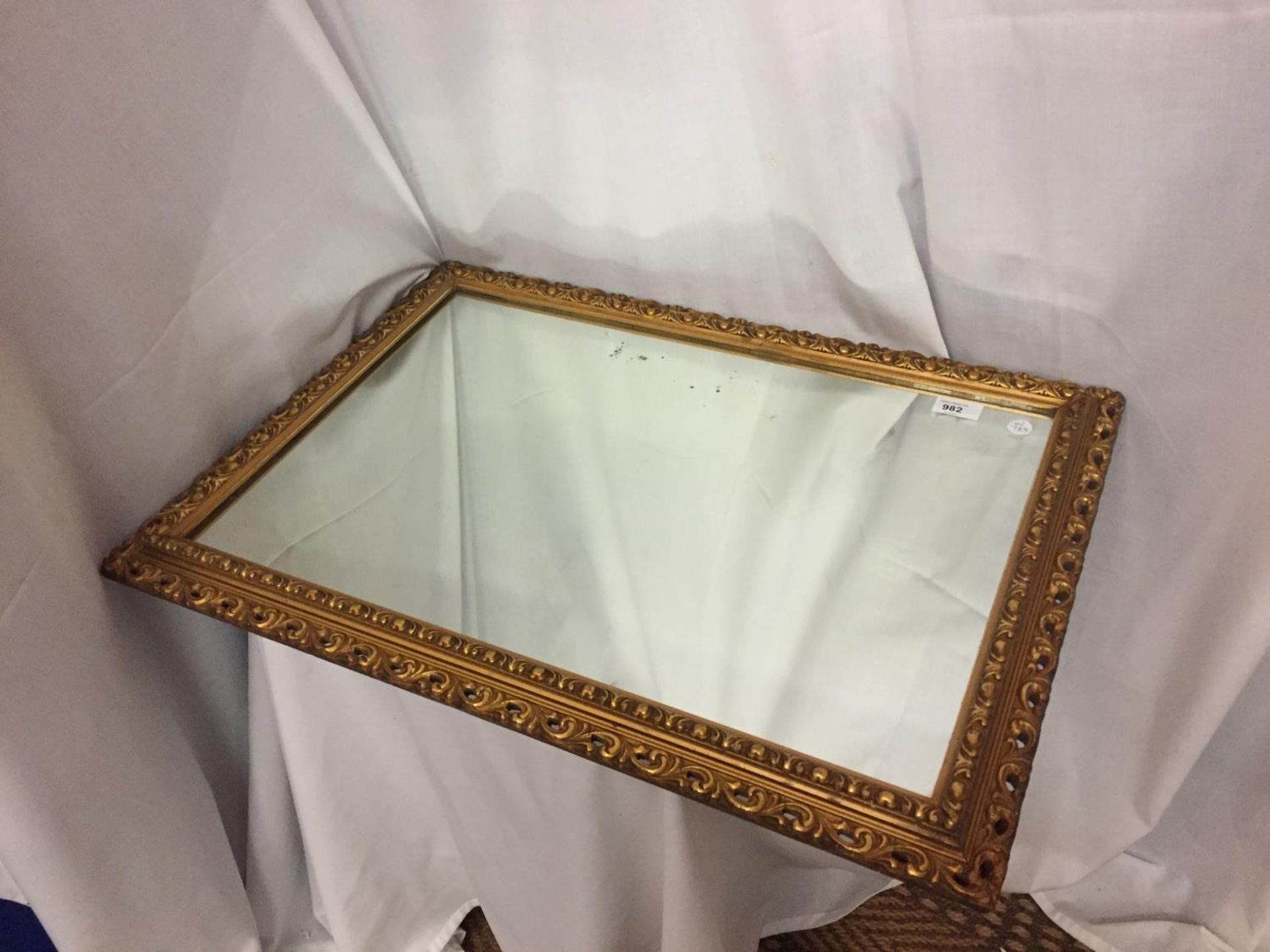 A GILT FRAMED MIRROR SIZE 27 INCHES X 19 INCHES