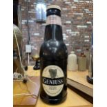 A LARGE PLASTIC BEER BOTTLE IN THE STYLE OF GUINNESS