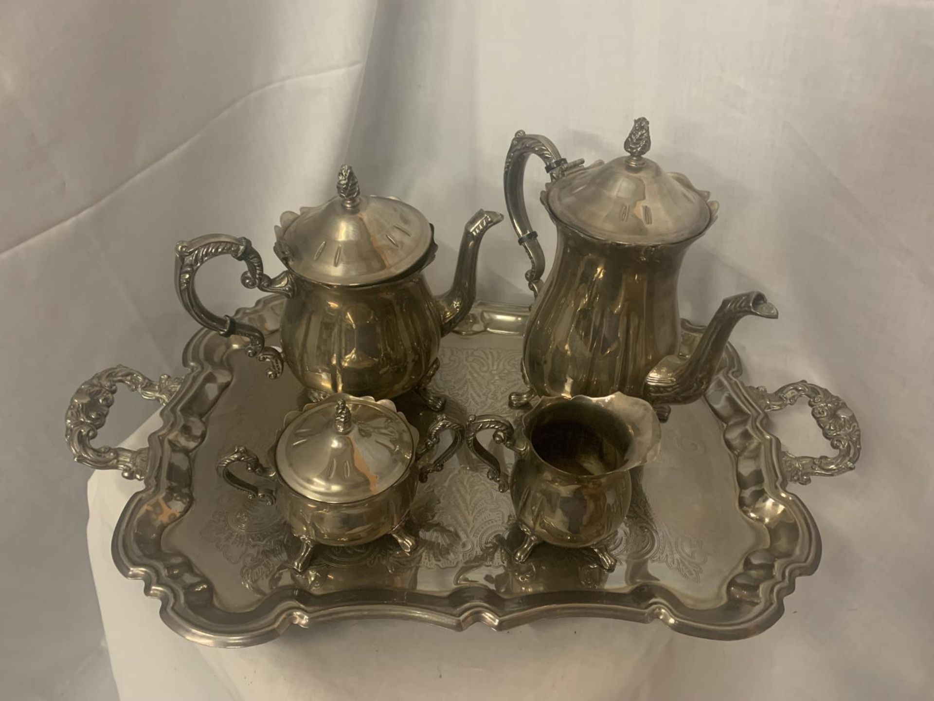 A VERY HEAVY AND ORNATE SILVER PLATED TEAPOT, COFFEE POT, SUGAR BOWL AND MILK JUG ON A TRAY