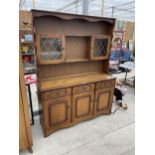 A REPRODUCTION OAK DRESSER WITH PLATE RACK HAVING GLAZED AND LEADED DOORS TO UPPER PORTION 54" WIDE