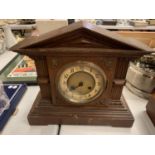 A WOODEN CASED MANTLE CLOCK COMPLETE WITH PENDULUM AND KEY