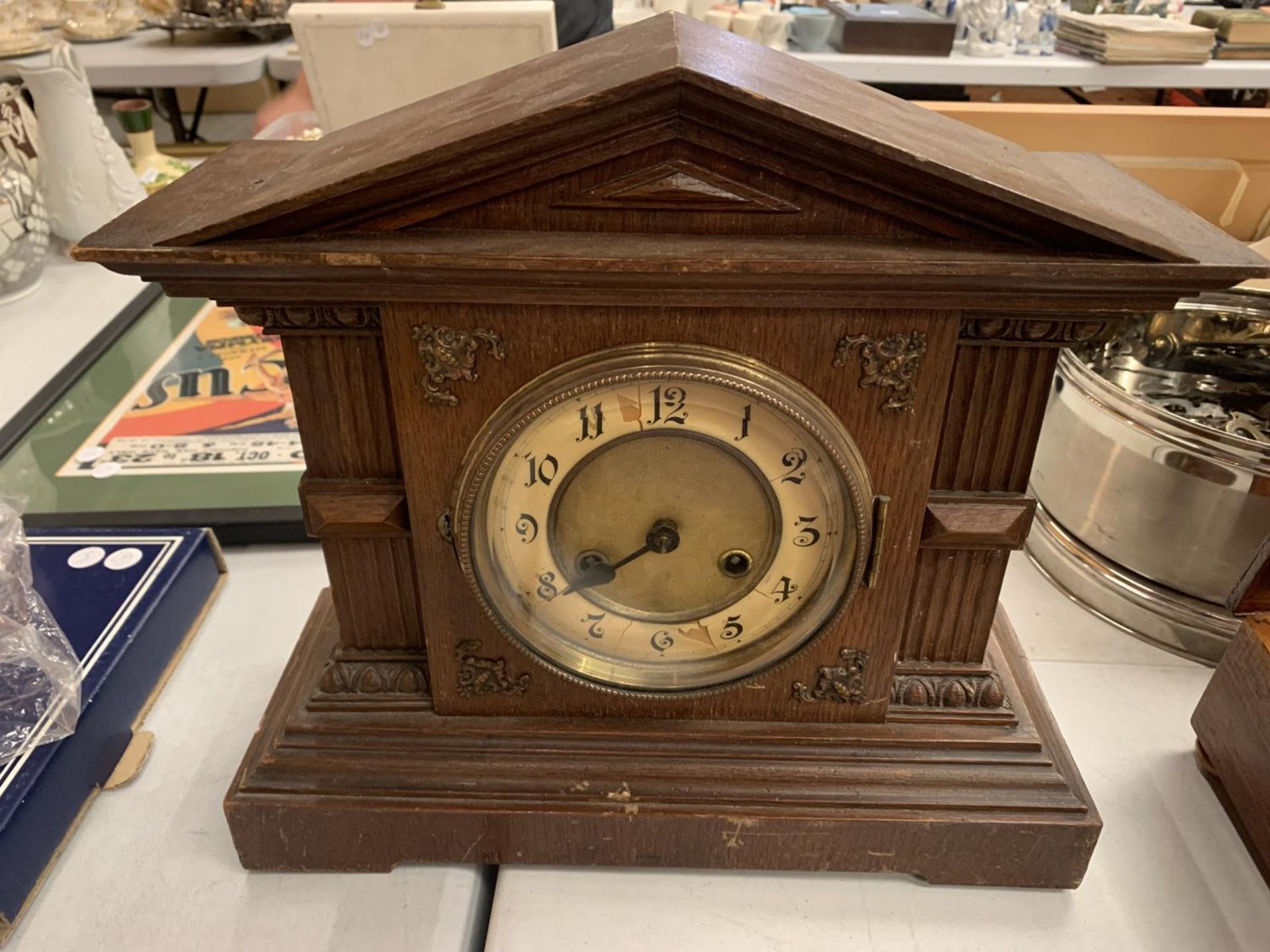 A WOODEN CASED MANTLE CLOCK COMPLETE WITH PENDULUM AND KEY