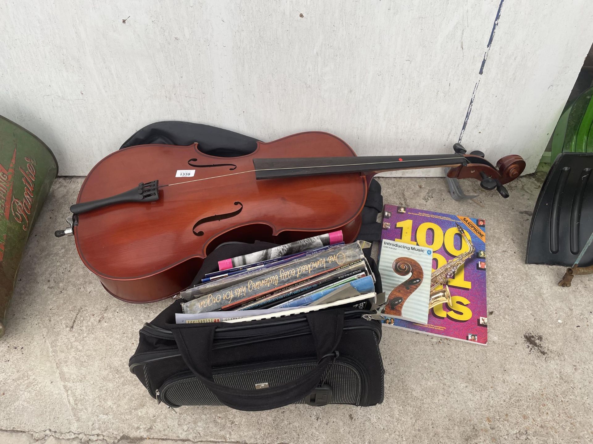 A LARGE ASSORTMENT OF MUSIC BOOKS AND A CELLO