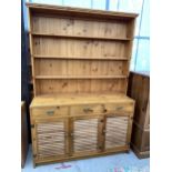 A MODERN PINE DRESSER WITH A PLATE RACK 53.5" WIDE