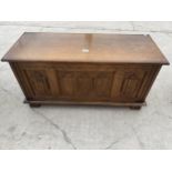 A SMALL REPRODUCTION OAK BLANKET CHEST WITH LINEN FOLD FRONT PANEL 37.5 INCHES WIDE
