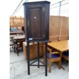 A GEORGE III OAK SINGLE DOOR CORNER CUPBOARD WITH SHAPED INTERIOR SHELVES ON AN OPEN BASE