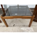 A RETRO TEAK FRAMED COFFEE TABLE WITH INSET SMOKED GLASS TOP 25" SQUARE