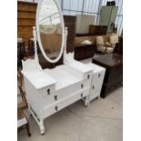 AN EARLY 20TH CENTURY WHITE DRESSING TABLE ON BARLEY TWIST SUPPORTS AND A MATCHING BEDSIDE CABINET