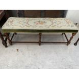 AN EARLY 20TH CENTURY LONG STOOL ON OAK BARLEY TWIST SUPPORTS WITH FLORAL TAPESTRY UPHOLSTERY