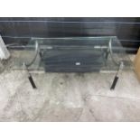 A RETRO GLASS TOPPED COFFEE TABLE 47" X 26" ON CHROME BASE HAVING BLACK LEGS AND FAUX LEATHER