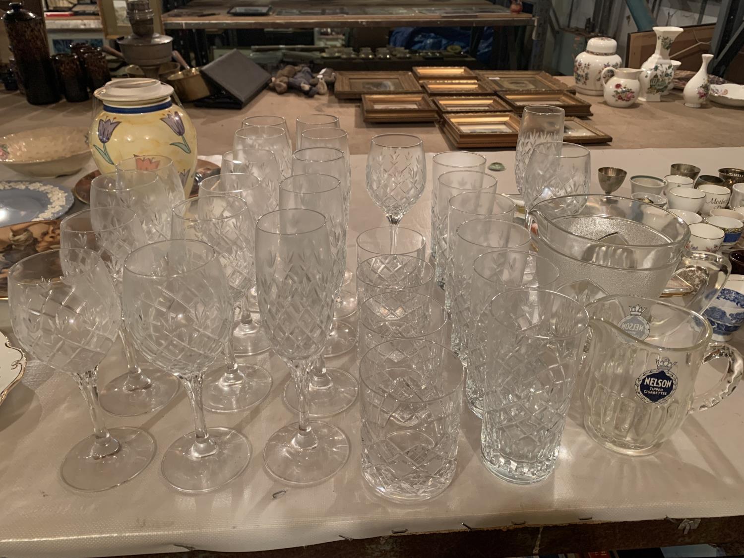 A COLLECTION OF GLASSES TO INCLUDE STEMMED WINE AND CHAMPAGNE GLASSES, WHISKEY TUMBLERS AND A NELSON