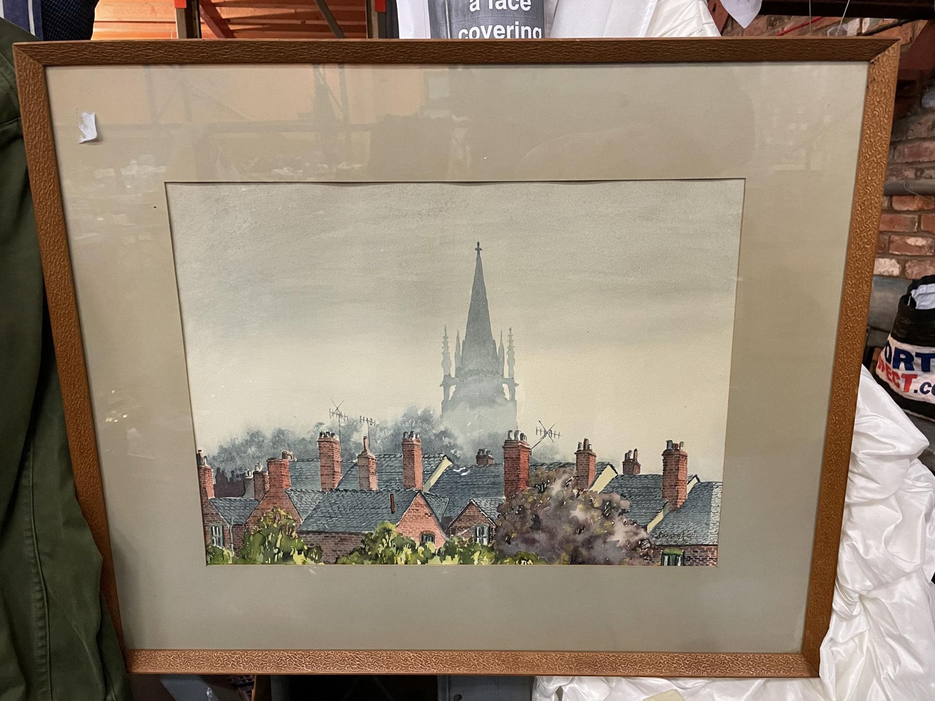 A FRAMED PICTURE OF HOUSE ROOFS AND A CHURCH