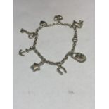 A SILVER CHARM BRACELET WITH EIGHT CHARMS TO INCLUDE A HORSESHOE, ANCHOR, KET, DOLPHIN, BUTTERFLY