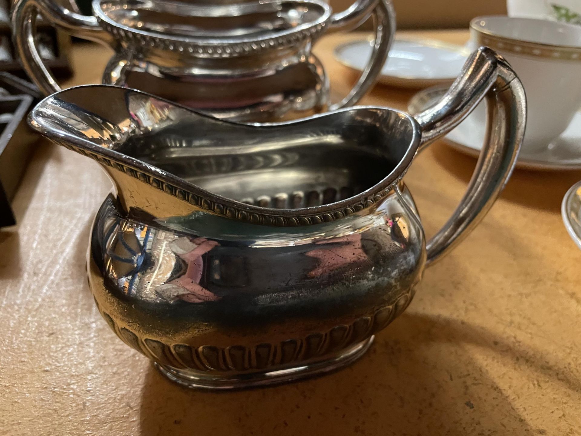 A THREE PART SILVER PLATED SET TO INCLUDE A TEAPOT, SUGAR BOWL AND MILK JUG - Image 2 of 4