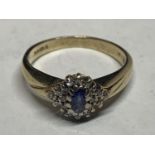 A 9 CARAT GOLD RING WITH A LIGHT BLUE STONE AND DIAMONDS IN A CLUSTER DESIGN SIZE L/M WITH A