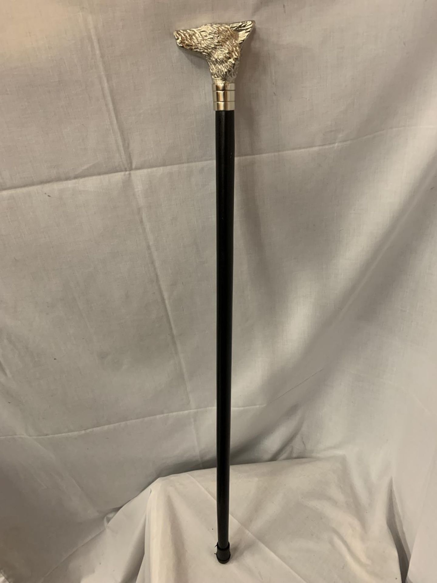 A WOODEN WALKING CANE WITH A SILVER COLOURED FOX HANDLE