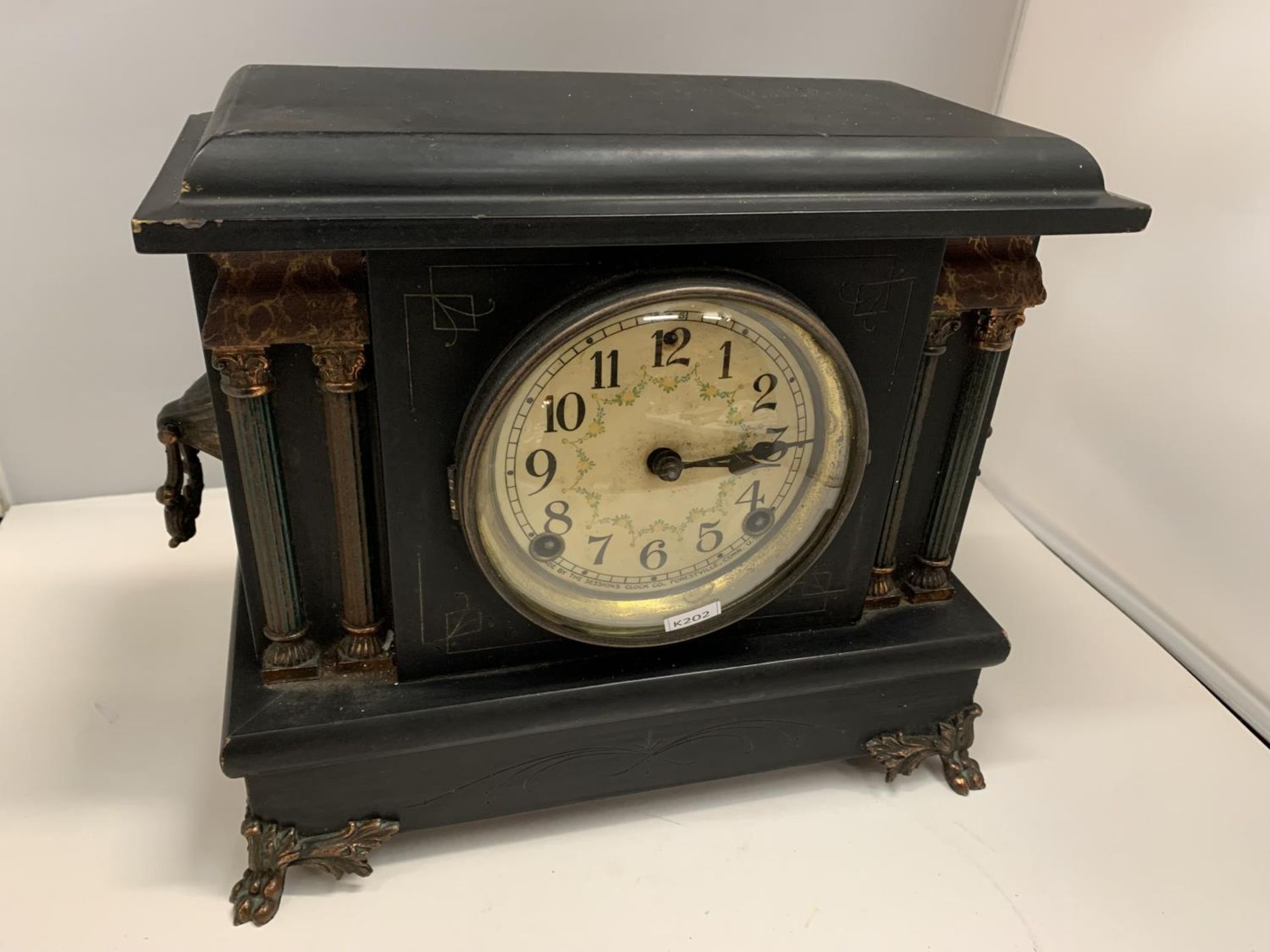 A DECORATIVE AMERICAN WOODEN MANTLE CLOCK WITH COLUMNS