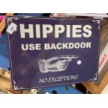 A TIN PLATE SIGN SAYING HIPPIES USE THE BACK DOOR