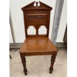 A VICTORIAN MAHOGANY HALL CHAIR ON TURNED FRONT LEGS FOLIATE PANEL TO THE BACK WITH A BROKEN SWAN