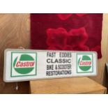 AN ILLUMINATED CASTROL SIGN