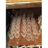 A LARGE QUANTITY OF DRINKING GLASSES TO INCLUDE CHAMPAGNE FLUTES, WINE GLASSES, TUMBLERS, ETC