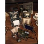 A LARGE AMOUNT OF PHOTO FRAMES SOME WITH PHOTOS IN THEM