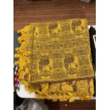 A HEAVY RUG/THROW IN A MUSTARD AND BROWN COLOUR WITH A LION INSPIRED GEOMETRIC PATTERN