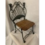 A VINTAGE VERY HEAVY WROUGHT IRON CHILDRENS CHAIR WITH A WOVEN SEAT