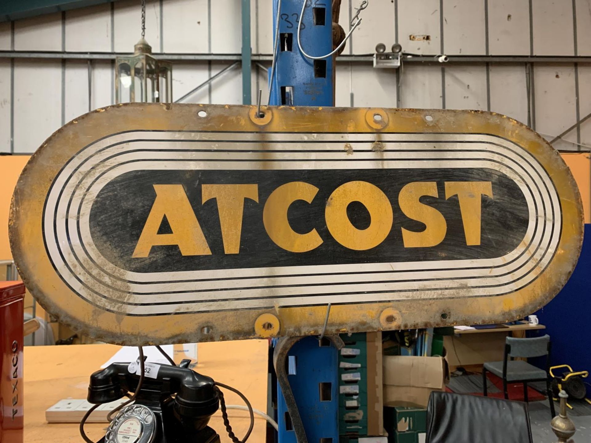 AN ATCOST ENAMEL SIGN