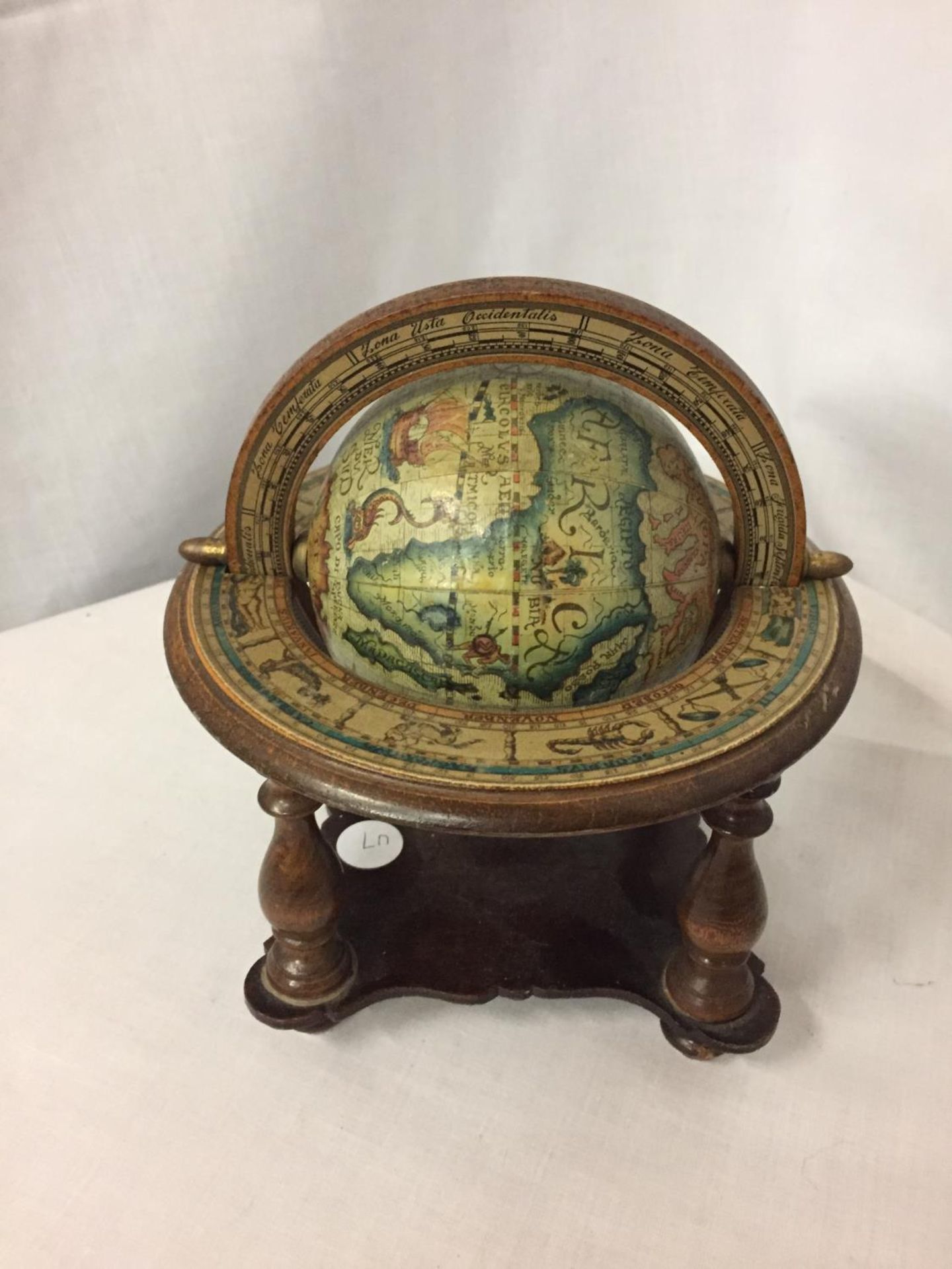 A SMALL WOODEN GLOBE ON A BASE HEIGHT APPROX 8 INCHES