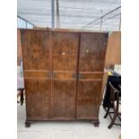 AN EARLY 20TH CENTURY WALNUT THREE DOOR WARDROBE 59" WIDE WITH HANGING SECTION, SLIDES AND TWO