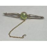 A TESTED TO 18 CARAT GOLD BROOCH WITH PALE GREEN CENTRE STONE GROSS WEIGHT 2.9 GRAMS