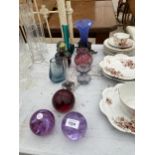 AN ASSORTMENT OF COLOURED GLASS ITEMS TO INCLUDE PAPER WEIGHTS, VASES AND A LAMP ETC