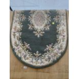 AN OVAL GREEN PATTERNED RUG
