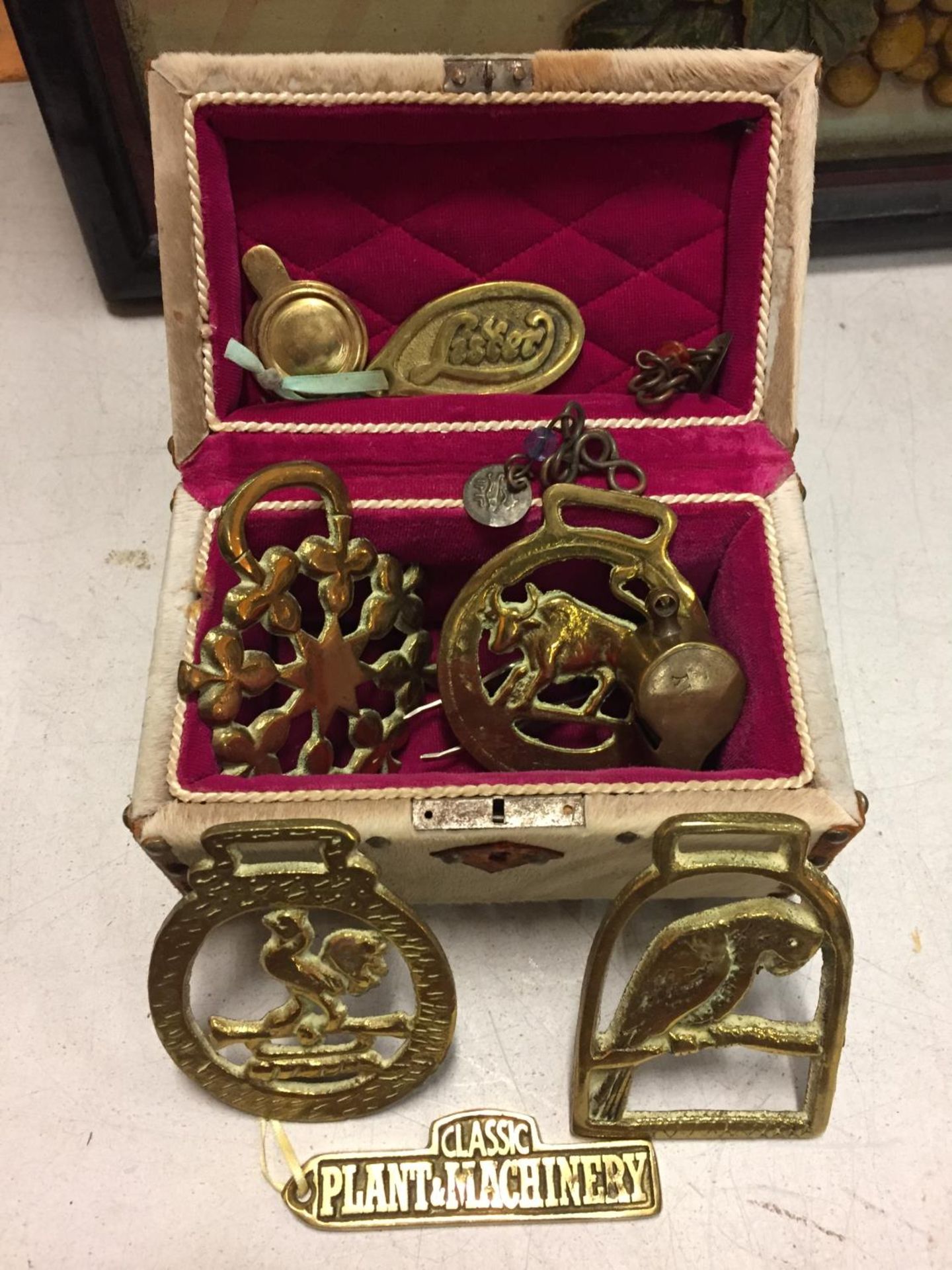 A MINATURE CHEST CONTAINING VARIOUS ITEMS OF BRASSWARE TO INCLUDE PLAQUES, HORSE BRASSES ETC