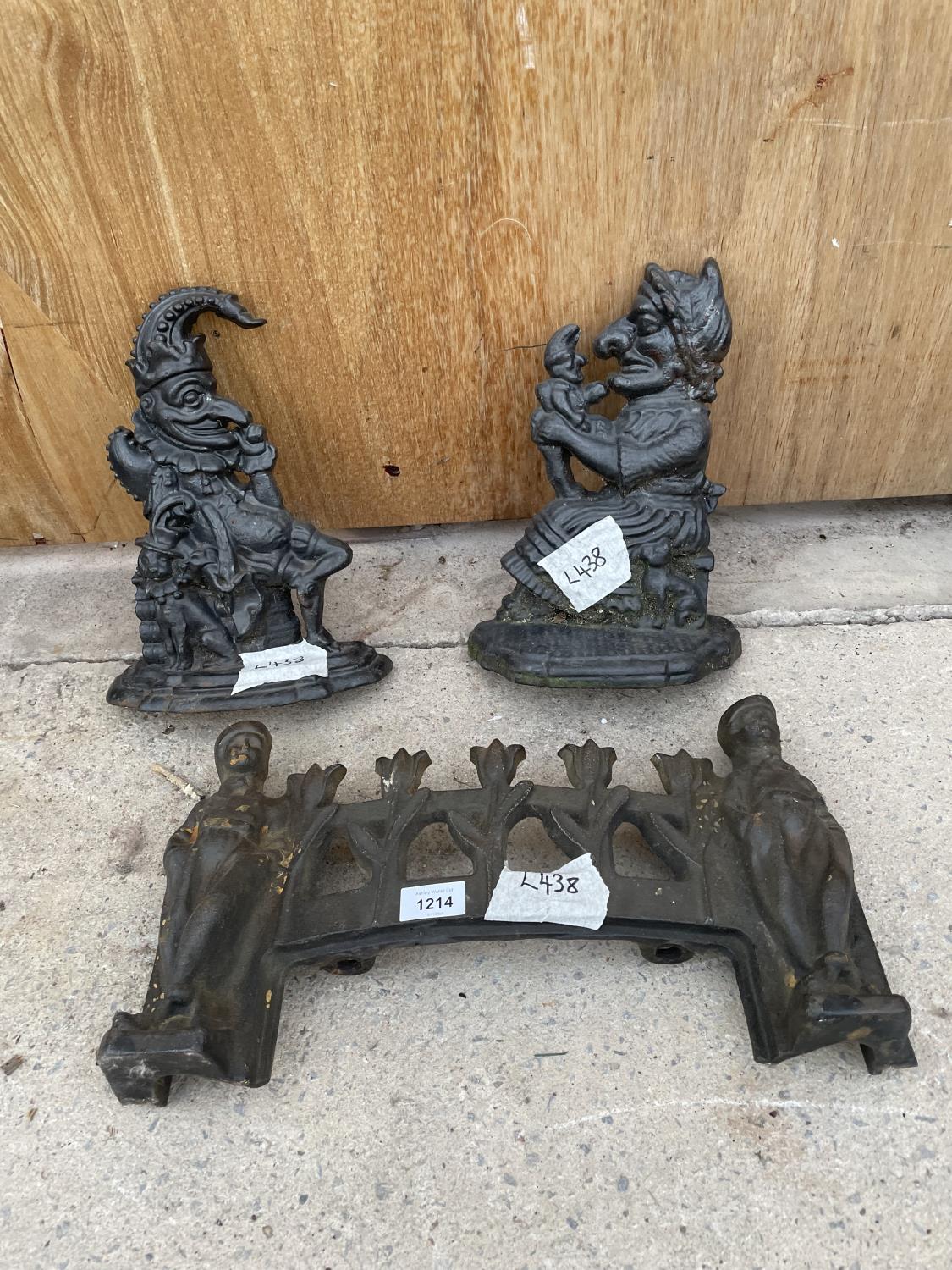 A PAIR OF CAST IRON PUNCH AND JUDY DOORSTOPS AND A DECORATIVE FIRE FRONT