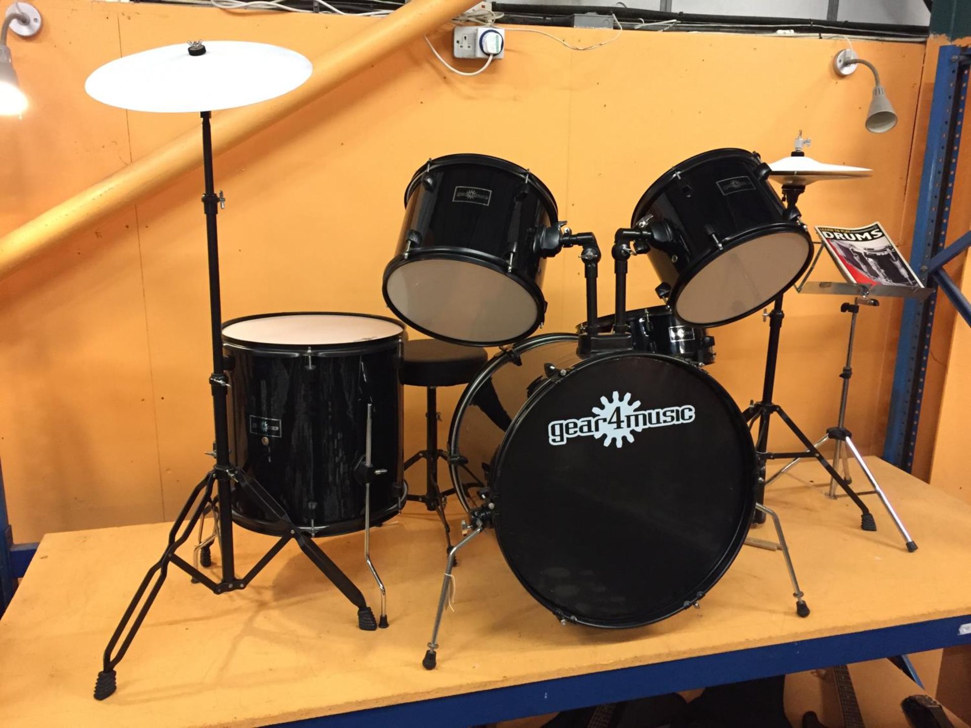 A BLACK GEAR FOR MUSIC DRUM KIT WITH MUSIC AND MUSIC STAND