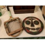 A PAINTED WOODEN MASK TYPE PLAQUE AND A STUART SURRIDGE AND CO LTD RACKET AND PRESS