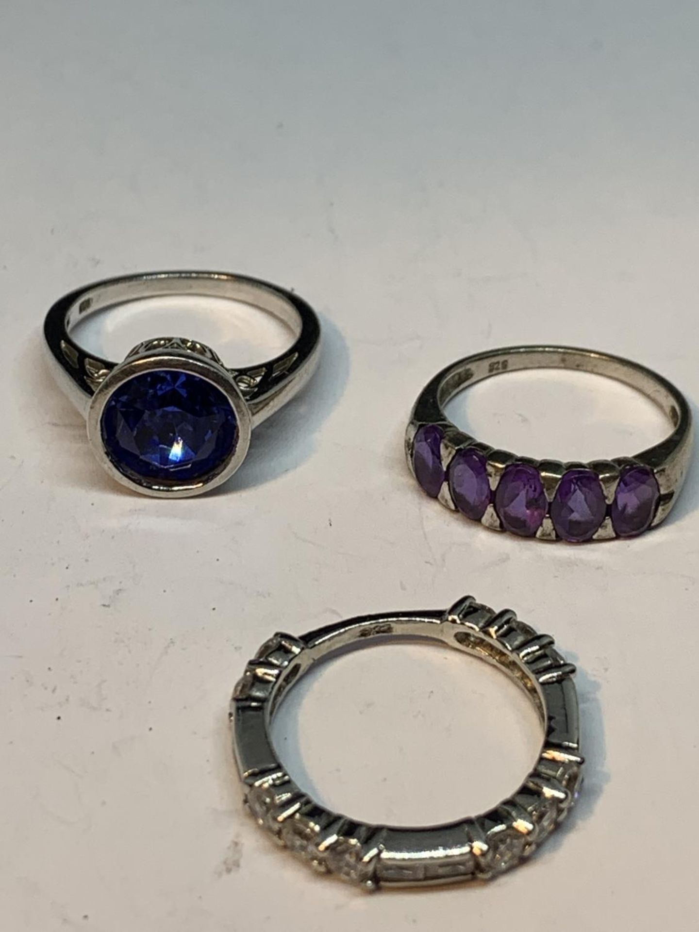 FIVE VARIOUS SILVER RINGS TO INCLUDE A BLUE STONE, PURPLESTONES, DOLPHINS ETC - Image 3 of 3