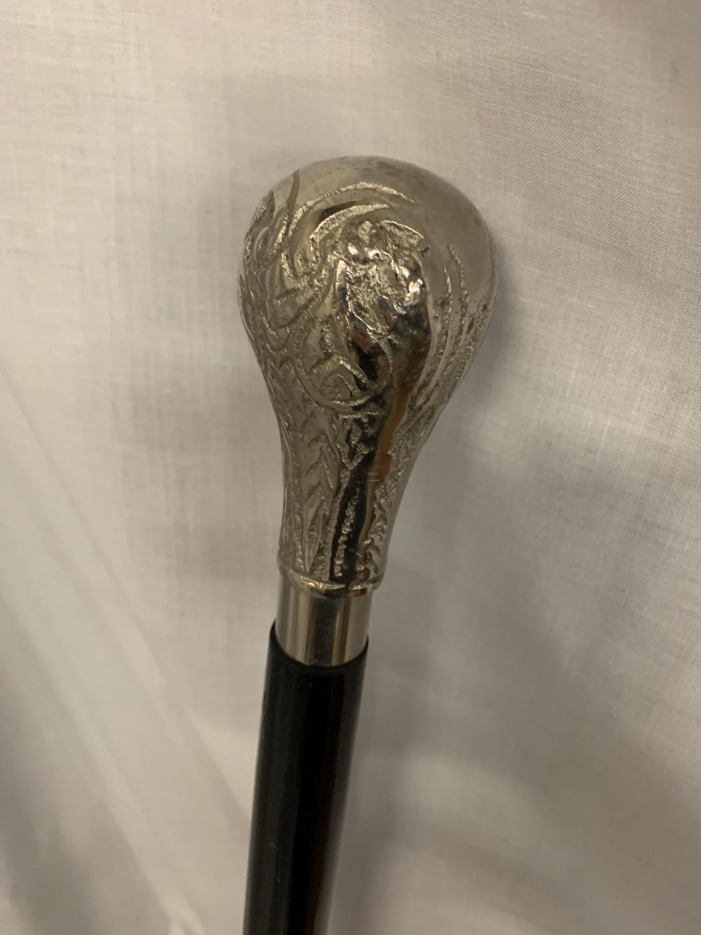 A BLACK WALKING CANE WITH WHITE METAL HANDLE - Image 2 of 3
