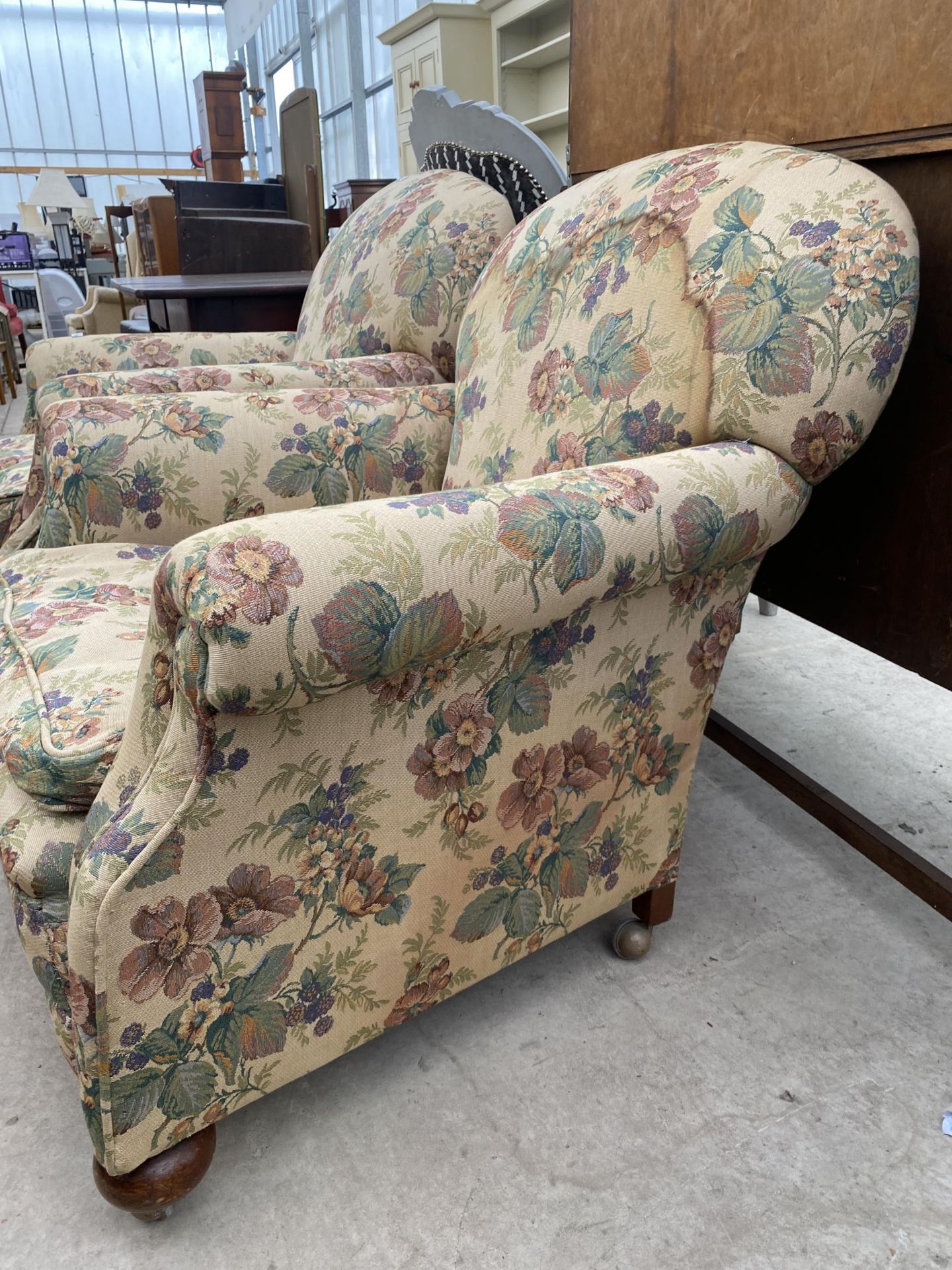 A PAIR OF EARLY 20TH CENTURY SPRUNG AND UPHOLSTERED EASY CHAIRS ON BUN FEET WITH A SPARE LOOSE COVER - Image 3 of 4