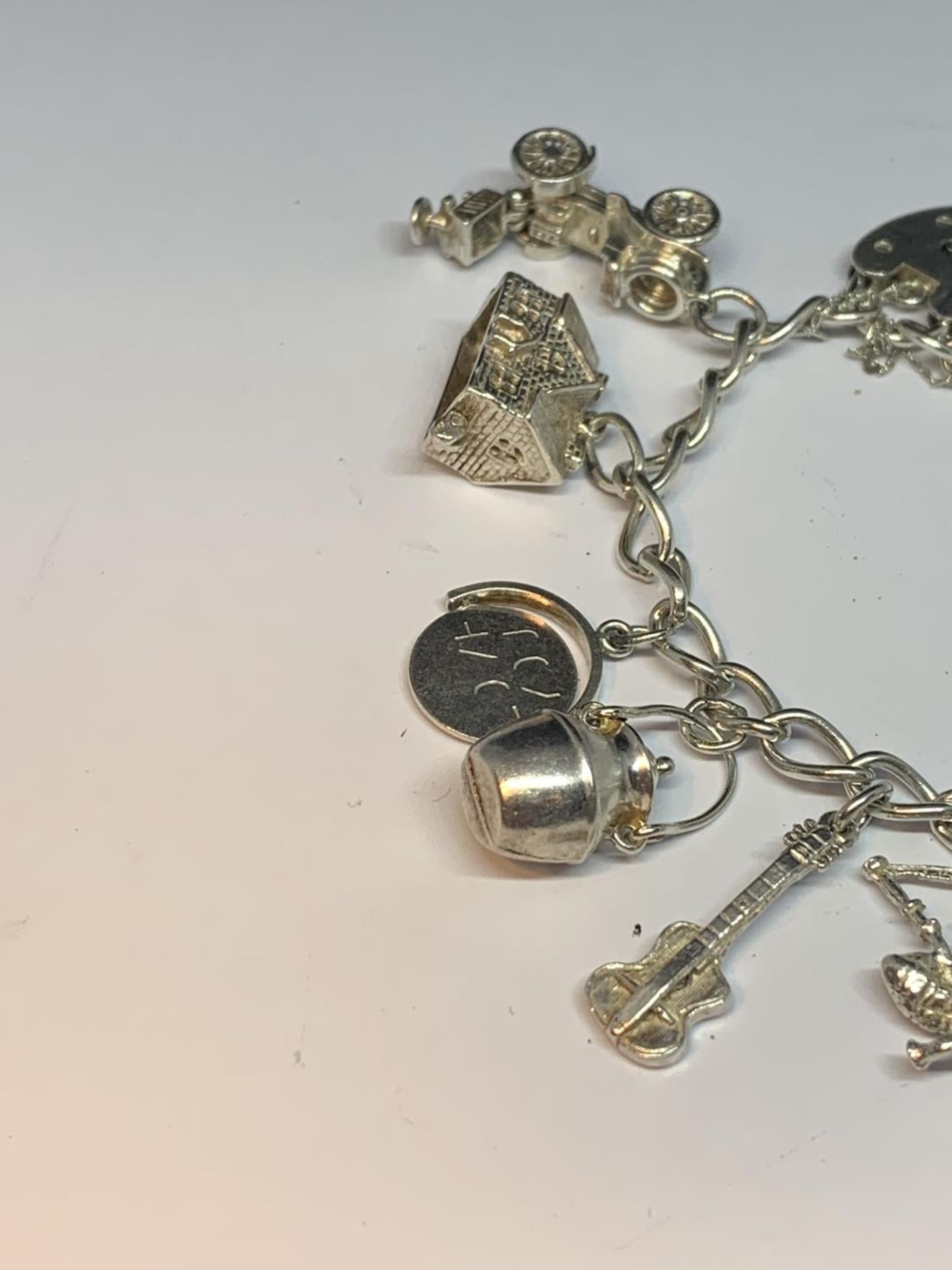 A SILVER CHARM BRACELET WITH TEN CHARMS AND A HEART LOCK - Image 2 of 3