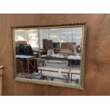 A DECORATIVE GILT FRAMED BEVELED EDGE WALL MIRROR